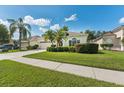 A well-maintained one story home with a large driveway, lush landscaping, and mature trees at 10409 Glen Willow Ln, Tampa, FL 33647
