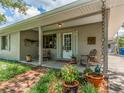 Inviting covered front porch with brick flooring and seating area, perfect for relaxing and enjoying the outdoors at 1136 Granada St, Clearwater, FL 33755