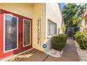 The home features double red doors with a welcome sign and quaint outdoor decor at 12234 Cider Mill Ln, Hudson, FL 34667