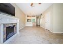 Inviting living room featuring a fireplace, ceiling fan, and access to the dining and kitchen areas at 1241 Redondo Way, Wesley Chapel, FL 33543