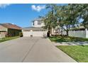 Two-story home with a three car garage, large driveway, and a well-maintained lawn at 13252 Graham Yarden Dr, Riverview, FL 33579