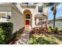 Welcoming front entrance showcases an arched doorway and neatly arranged landscaping at 13252 Graham Yarden Dr, Riverview, FL 33579