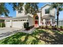 Charming two-story home featuring a well-manicured lawn and a front entrance with an arched doorway at 13252 Graham Yarden Dr, Riverview, FL 33579