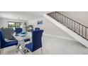 Dining area with a glass table, blue chairs, and modern staircase at 1712 Azalea Ct # A, Oldsmar, FL 34677