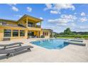 The back exterior shows a large pool with a spa and covered patio at 17914 Howsmoor Pl, Lutz, FL 33559
