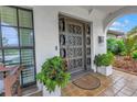 Ornate metal front door with decorative plants and a tiled porch creates a welcoming entrance to the home at 1960 Kansas Ne Ave, St Petersburg, FL 33703
