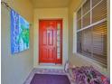 Inviting front entryway with a red front door, decorative welcome sign and a window at 2239 Sifield Greens Way # 84, Sun City Center, FL 33573