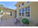 Side view of a home with brick patio, and a chair, showcasing architecture and outdoor space for relaxation at 2239 Sifield Greens Way # 84, Sun City Center, FL 33573