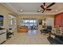 Spacious living room with tile floors, ceiling fan, and sliding glass doors overlooking a picturesque lake at 2239 Sifield Greens Way # 84, Sun City Center, FL 33573