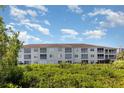 Exterior view of the condo building featuring screened balconies and mature landscaping at 2725 Terra Ceia Bay Blvd # 104, Palmetto, FL 34221
