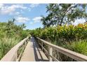 Wooden walkway surrounded by tropical landscaping under a bright blue sky at 2725 Terra Ceia Bay Blvd # 104, Palmetto, FL 34221