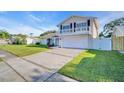 Charming two-story home boasts a well-manicured lawn, balcony, and an attached two-car garage at 2897 Rosery Ne Rd, Largo, FL 33771