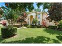 Beautifully landscaped home with mature trees and a lush, green lawn at 3042 Wentworth Way, Tarpon Springs, FL 34688