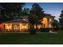 Stunning home at twilight with warm exterior lighting and manicured landscaping at 3042 Wentworth Way, Tarpon Springs, FL 34688