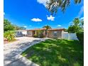 Quaint single-story house with a lush lawn and a long, paved driveway at 3303 W Idlewild Ave, Tampa, FL 33614