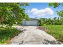 Single-story home with a gray exterior, an attached garage and a large concrete driveway at 4101 Shore Acres Ne Blvd, St Petersburg, FL 33703