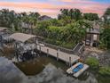 Waterfront property featuring a private dock with a boat lift, lush tropical landscaping, and a serene setting at 4615 Shark Dr, Bradenton, FL 34208