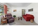Inviting living room with plush seating, carpet, and a decorative table with vase at 4917 99Th N St, St Petersburg, FL 33708
