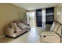 Cozy living room with tile flooring and a comfortable seating area bathed in natural light at 5016 S 86Th St, Tampa, FL 33619