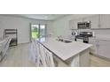 Stylish kitchen with stainless steel appliances, a large center island, and ample counter space at 5438 Summer Sunset Dr, Apollo Beach, FL 33572