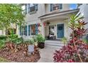 Inviting front porch with a charming blue door, colorful plants, and welcoming decor at 5918 Beaconpark St, Lithia, FL 33547