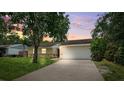 Charming one-story home with a well-maintained lawn and inviting curb appeal at dusk at 602 Timber Bay W Cir, Oldsmar, FL 34677
