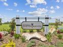 Entrance sign for Cottages at Oyster Bayou, surrounded by tropical landscaping and stone accents at 6715 Wander Ln, New Port Richey, FL 34654