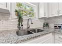 Close-up on a granite countertop and stainless steel sink in a bright, updated kitchen at 6806 N 17Th St, Tampa, FL 33610