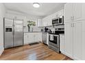 Bright kitchen featuring white cabinets, stainless steel appliances, and hardwood floors at 6806 N 17Th St, Tampa, FL 33610