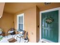 Inviting porch with green door, welcome wreath, and seating area at 6925 Marble Fawn Pl, Riverview, FL 33578
