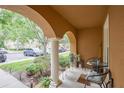 Charming porch with arched columns, seating, and view of the neighborhood at 6925 Marble Fawn Pl, Riverview, FL 33578
