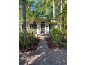 Inviting home entrance with a brick path and tropical landscaping provides curb appeal at 715 Riverside Dr, Tarpon Springs, FL 34689