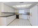 Bright kitchen featuring white cabinets, black countertops, and tile flooring at 739 Chesapeake Dr, Tarpon Springs, FL 34689