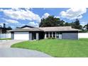 Inviting single-story home with a well-manicured front lawn and a bright garage door at 800 Embassy Rd, Largo, FL 33771