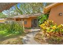 Charming home entrance with a stone accent wall and colorful landscaping at 8268 Garrison St, Spring Hill, FL 34606