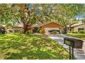 Inviting home with a well-manicured lawn, mature trees, and a spacious driveway at 8268 Garrison St, Spring Hill, FL 34606