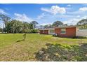 Well-maintained home with brick accents, showcasing a spacious front yard and landscaping at 8310 Pat Blvd, Tampa, FL 33615