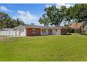 Inviting home with a brick facade, attached garage, and a spacious green front yard at 8310 Pat Blvd, Tampa, FL 33615