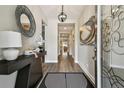Inviting entryway with stylish decor, wood flooring, and an open view into the home at 9316 Crescent Ray Dr, Wesley Chapel, FL 33545