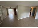 Open-concept living area with neutral tile floors, perfect for modern living and easy maintenance at 9411 Rainbow Ln, Port Richey, FL 34668