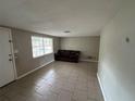 Bright living room with tile flooring, a large window, and a comfortable sofa for relaxation and entertainment at 9411 Rainbow Ln, Port Richey, FL 34668