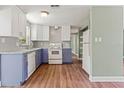 Modern kitchen with stainless steel appliances, granite countertops, and a combination of white and blue cabinets at 10039 Old Hickory Ln, Port Richey, FL 34668