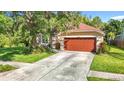 Well-maintained home featuring a two-car garage, landscaping, and a cozy front porch at 10323 Birdwatch Dr, Tampa, FL 33647
