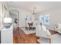 Bright dining room featuring wood floors, modern chandelier, and large window with views of the backyard at 10364 Lightner Bridge Dr, Tampa, FL 33626
