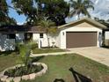 Charming home with a new garage door and an inviting front lawn with beautiful landscaping at 10999 Del Prado E Dr, Largo, FL 33774
