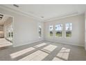 Airy bedroom featuring neutral carpet, tray ceiling, and a wall of windows at 11622 Gleaming Ter, Venice, FL 34293