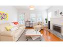 Bright living room featuring hardwood floors, a fireplace, and plenty of natural light with stylish décor at 1202 E Mohawk Ave, Tampa, FL 33604