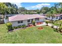 Charming single-story home featuring a well-maintained lawn and colorful, landscaped flowerbeds at 1223 Jasmine Way, Clearwater, FL 33756