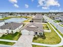 Aerial view of a single-Gathering home showing a pond, and a well-manicured lawn at 12351 Nouveau Ave, Spring Hill, FL 34610