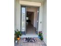 Inviting entryway with a decorative doormat, sidelight window, and tiled flooring at 12351 Nouveau Ave, Spring Hill, FL 34610